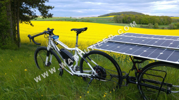 Vélo électrique avec remorque transportant des panneaux solaires flexibles.