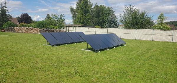 Photovoltaic panels installed on a ground-mounted structure in a green garden