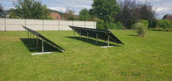 Photovoltaic panels installed on a ground-mounted structure in a green garden