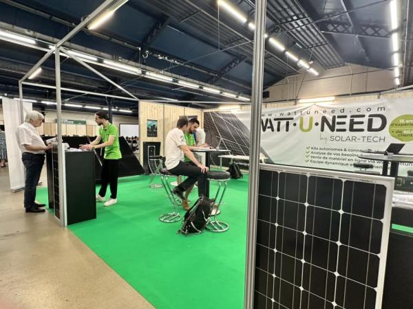 Wattuneed booth at Survival Expo – Autonomy & Outdoor: Vivre Autonome, the Sustainable Home Fair, with customers, Wattuneed employees, and Wattuneed products including solar panels and inverters