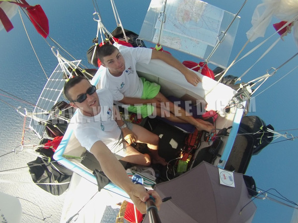 Hervé Moine et Eric Decellieres en vol sur un ballon équipé de panneaux solaires au milieu des nuages avec le logo Wattuneed.