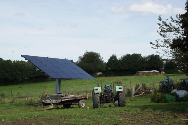 Suiveurs solaires avec panneaux photovoltaïques dans un champ et un tracteur