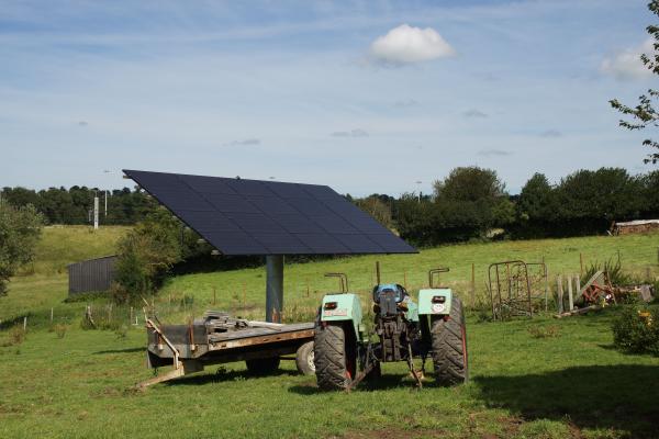 Suiveurs solaires avec panneaux photovoltaïques dans un champ et un tracteur