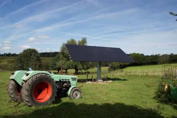 Suiveurs solaires avec panneaux photovoltaïques dans un champ et un tracteur